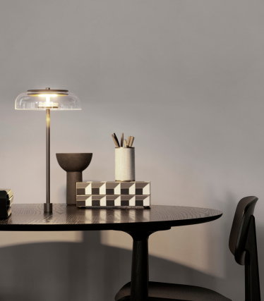 Elegantní stolní lampa na moderním pracovním stole se stylovými bytovými doplňky.