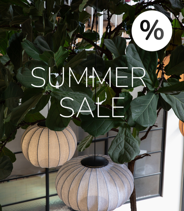 Látková závěsná svítidla na pozadí bujné zeleně s oznámením Summer Sale.